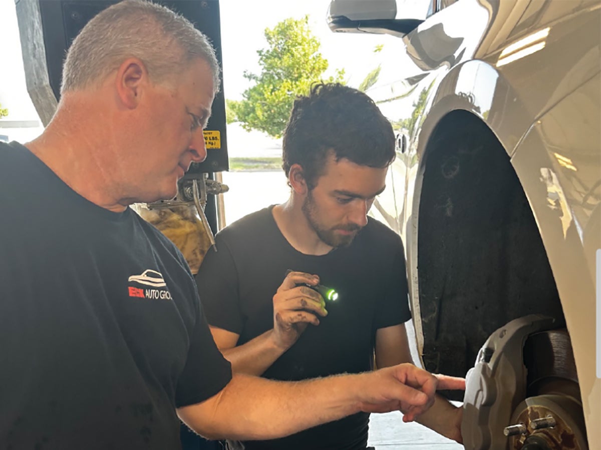 Young automotive technician using professional vehicle diagnostic equipment